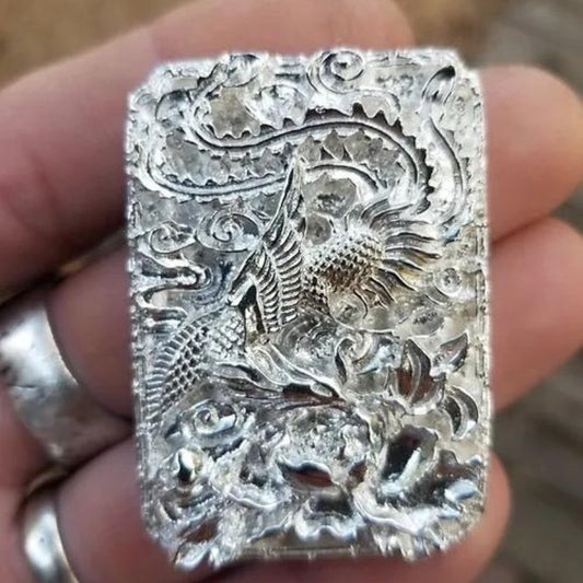 Hand-poured silver bar featuring a detailed design of the phoenix rising from the ashes, symbolizing transformation and renewal.