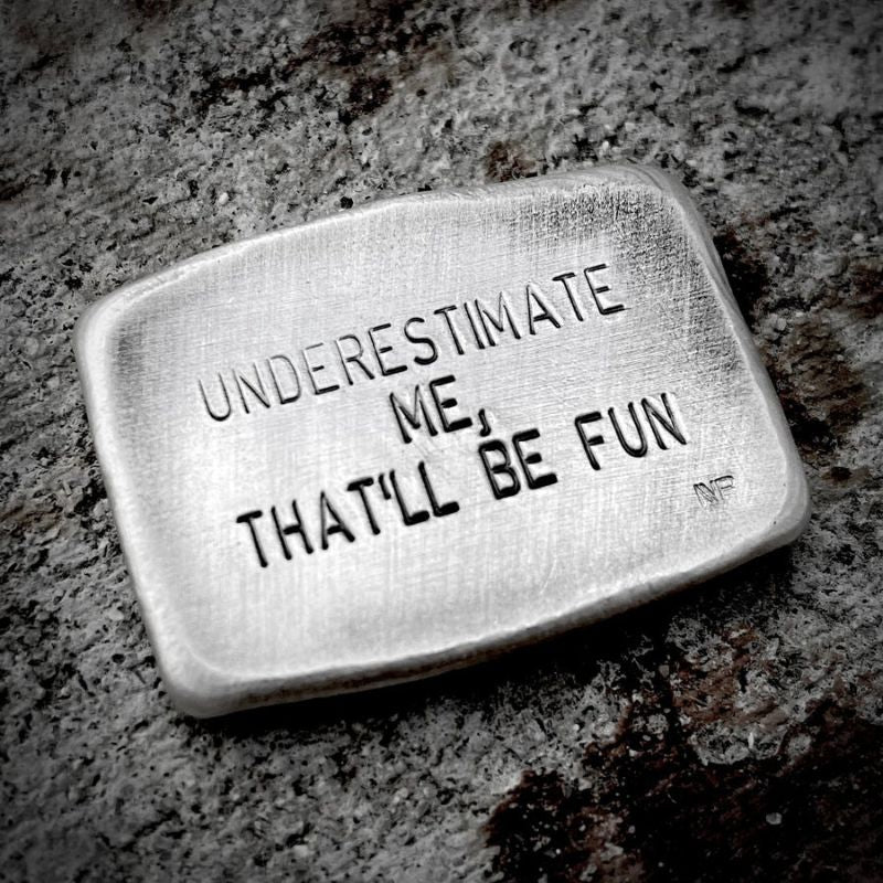 UNDERESTIMATE ME' Hand Poured Silver showcasing its empowering design and unique craftsmanship.